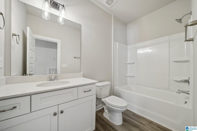 full bathroom featuring wood-type flooring, toilet, tub / shower combination, and vanity