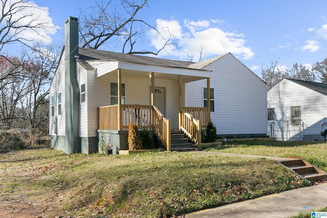 view of front of house with a porch and a front yard