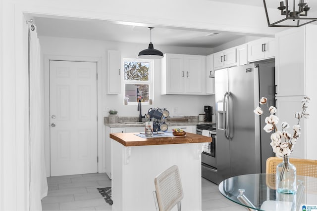 kitchen with sink, wooden counters, white cabinetry, stainless steel appliances, and decorative light fixtures