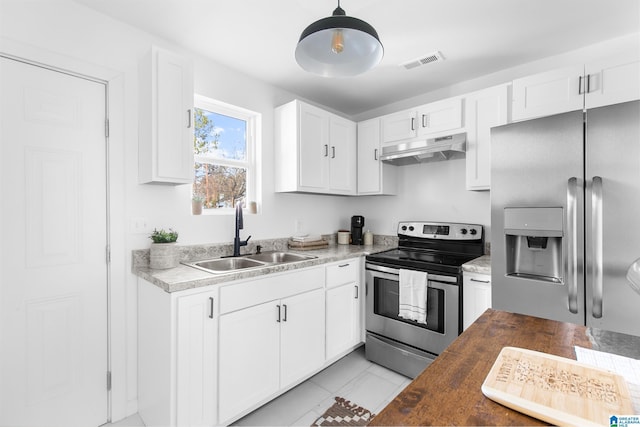 kitchen with appliances with stainless steel finishes, wood counters, sink, white cabinets, and hanging light fixtures