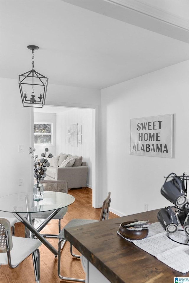 dining space featuring hardwood / wood-style flooring and an inviting chandelier