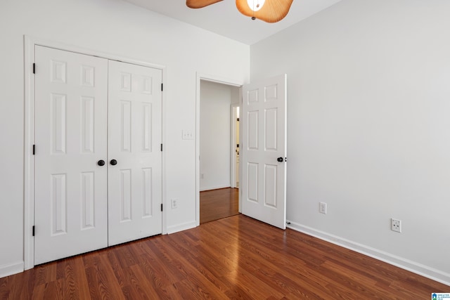 unfurnished bedroom with dark wood-type flooring, ceiling fan, and a closet