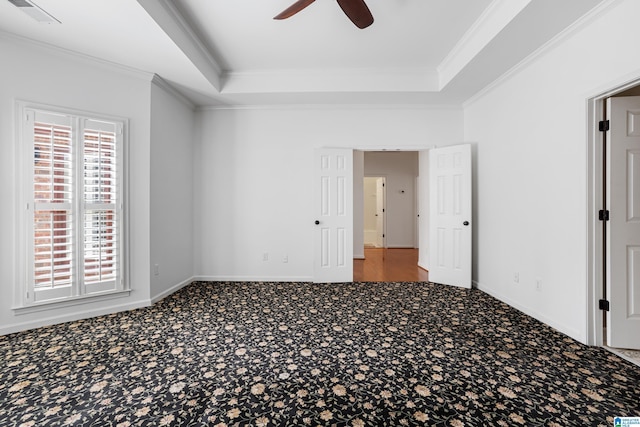 unfurnished bedroom featuring a raised ceiling, ornamental molding, carpet flooring, and ceiling fan