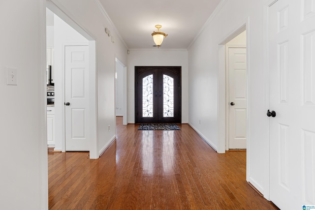 foyer with hardwood / wood-style flooring, crown molding, and french doors