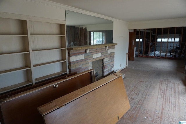 unfurnished living room with ornamental molding, a stone fireplace, and hardwood / wood-style floors