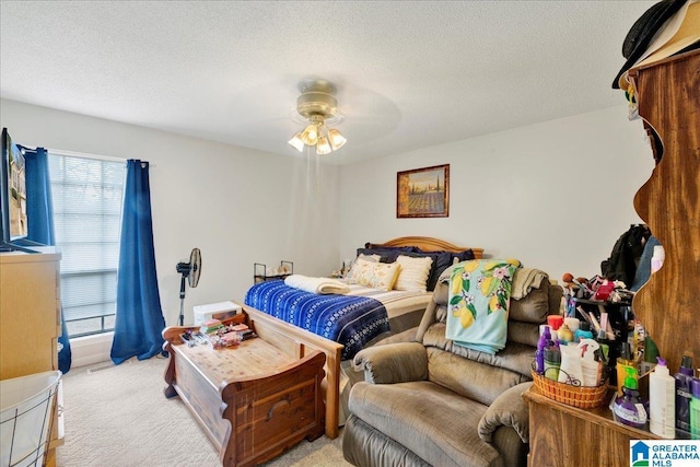 carpeted bedroom featuring ceiling fan and a textured ceiling