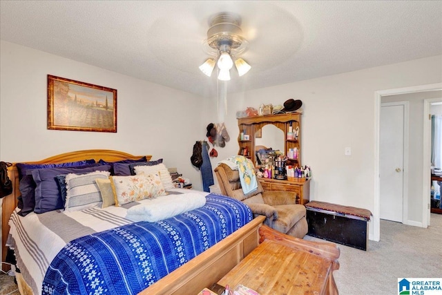 carpeted bedroom with ceiling fan and a textured ceiling