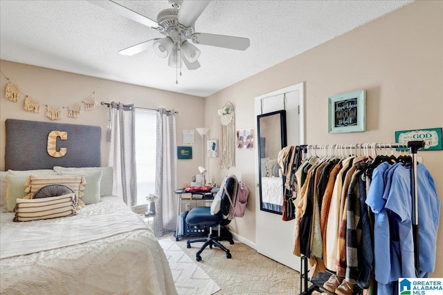 bedroom featuring ceiling fan, light colored carpet, and a textured ceiling