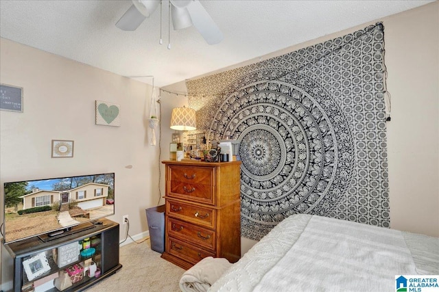 carpeted bedroom with ceiling fan and a textured ceiling