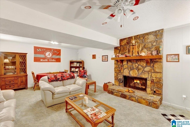 living room featuring ceiling fan, a fireplace, a textured ceiling, and carpet