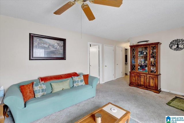 carpeted living room with ceiling fan and a textured ceiling