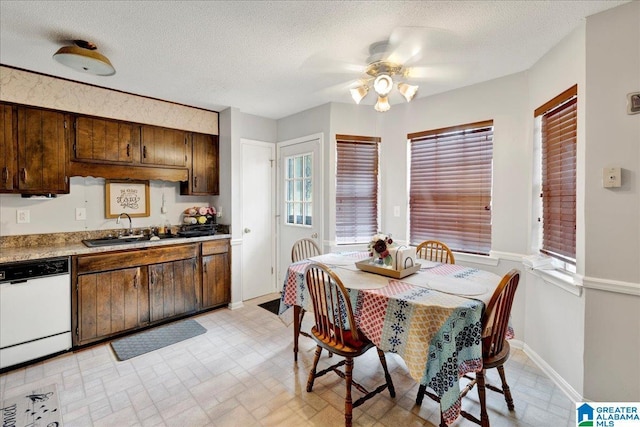 dining space with ceiling fan, sink, and a textured ceiling