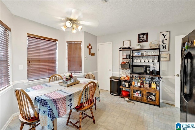 dining area featuring ceiling fan and a textured ceiling