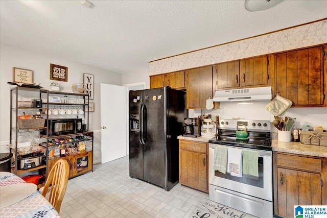 kitchen with black fridge, stainless steel range with electric stovetop, and a textured ceiling