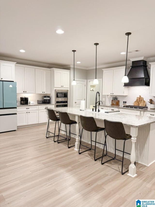 kitchen with pendant lighting, stainless steel appliances, custom exhaust hood, and white cabinets