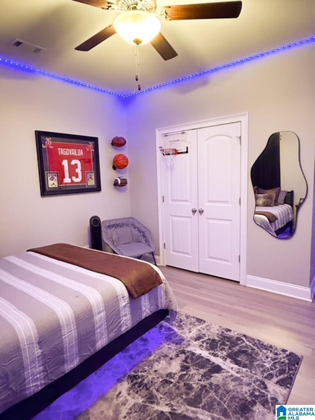 bedroom featuring wood-type flooring, a closet, and ceiling fan