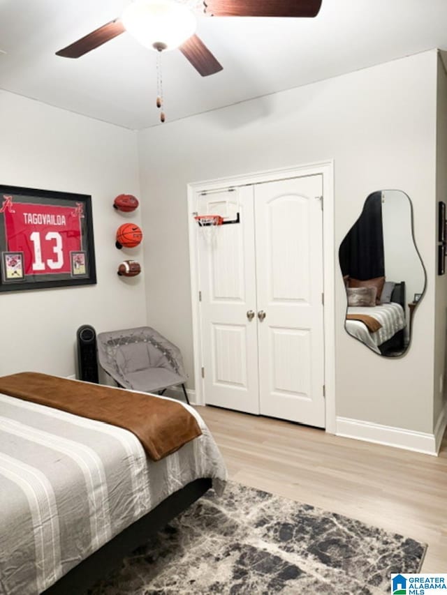 bedroom featuring ceiling fan, a closet, and light wood-type flooring