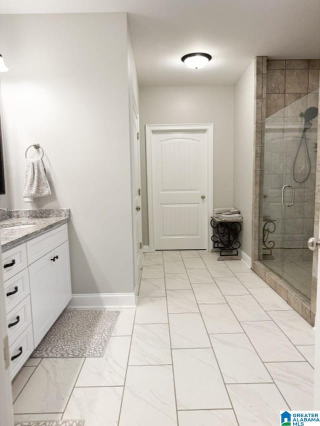 bathroom featuring vanity and a shower with door