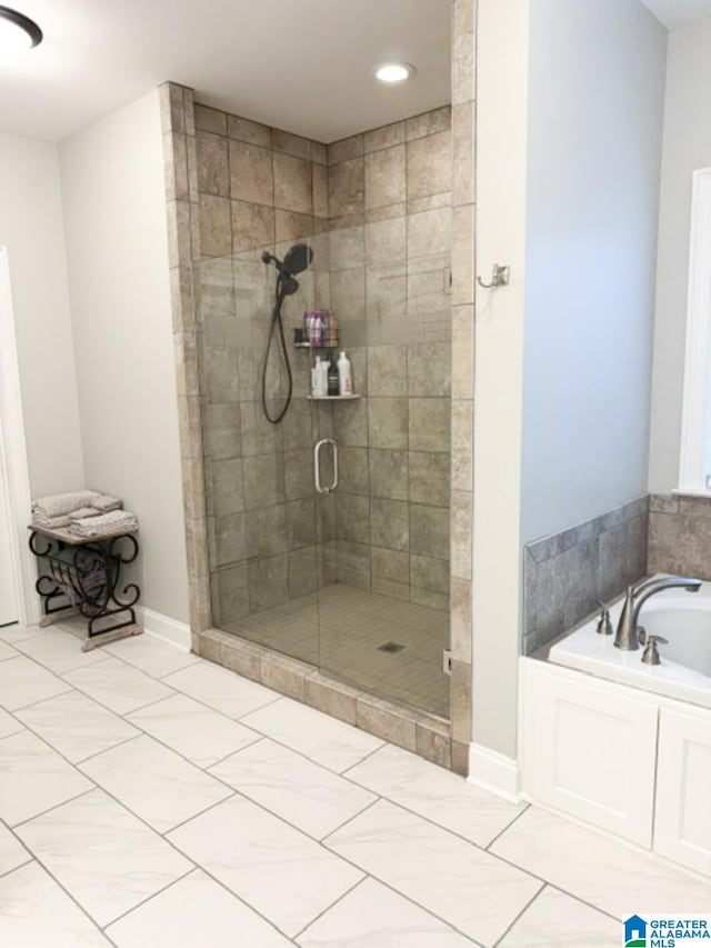 bathroom featuring independent shower and bath