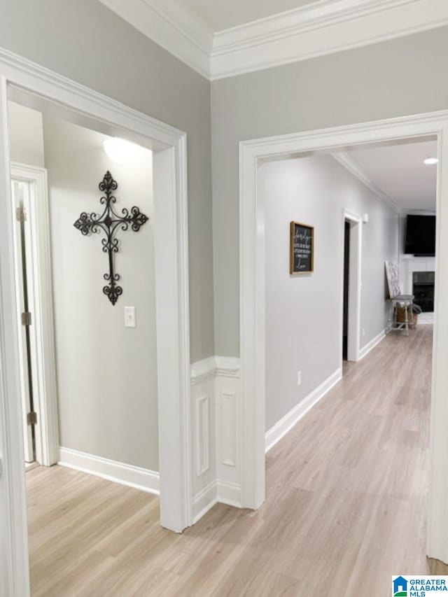 hall with light hardwood / wood-style flooring and ornamental molding