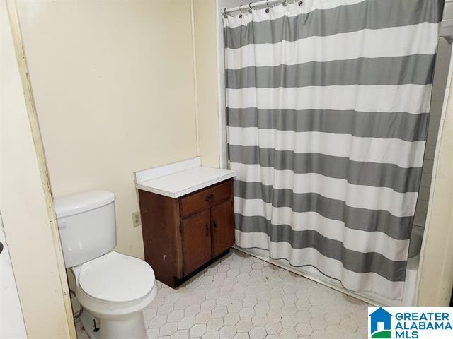 bathroom with toilet and a shower with curtain