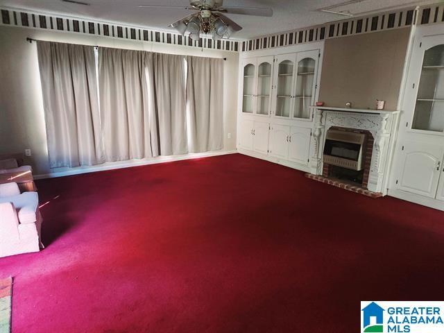 unfurnished living room with ceiling fan and carpet