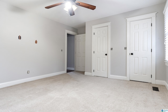 unfurnished bedroom with light colored carpet and ceiling fan