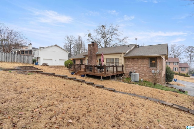 rear view of property featuring cooling unit and a wooden deck