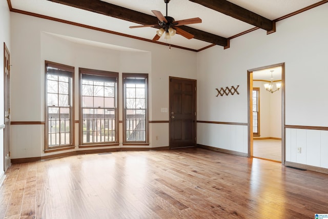 empty room with beamed ceiling, crown molding, ceiling fan with notable chandelier, and light wood-type flooring