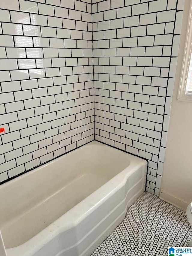 bathroom featuring tiled shower / bath combo and tile patterned floors