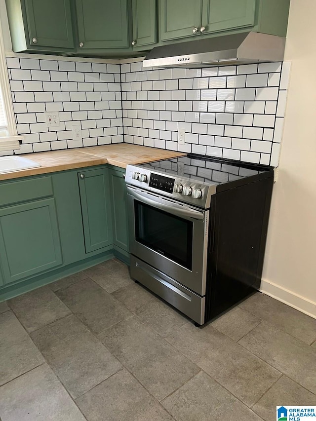 kitchen featuring green cabinetry, tasteful backsplash, butcher block countertops, and electric stove