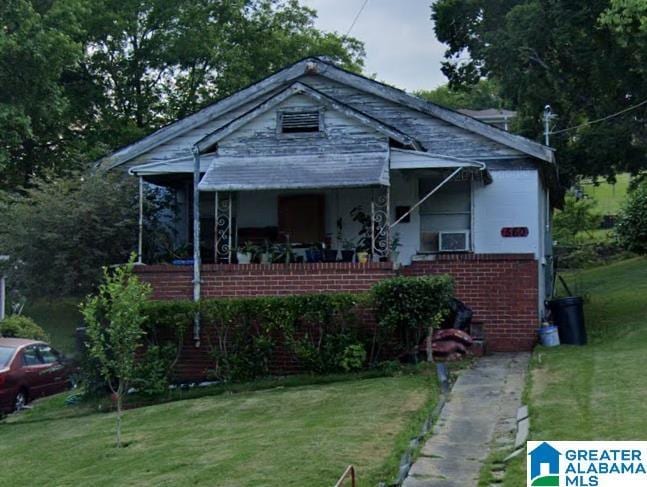 bungalow-style home with a front yard