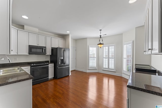 kitchen with white cabinetry, sink, hanging light fixtures, black appliances, and dark wood-type flooring