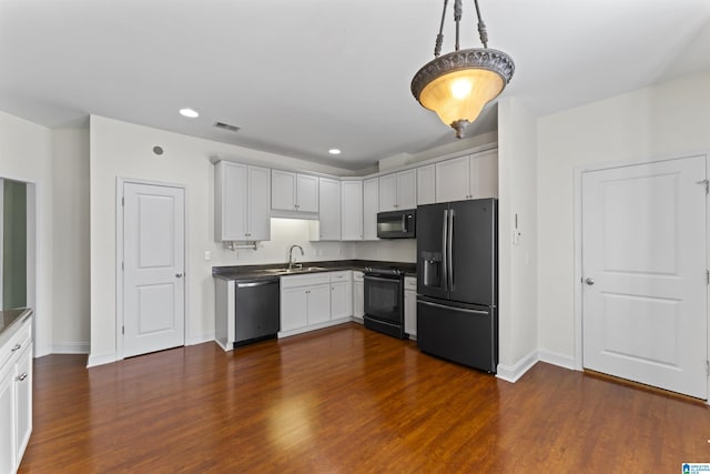 kitchen with sink, white cabinetry, hanging light fixtures, black appliances, and dark hardwood / wood-style flooring