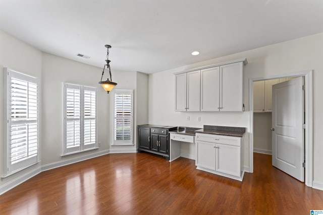 kitchen featuring white cabinetry, decorative light fixtures, and dark wood-type flooring