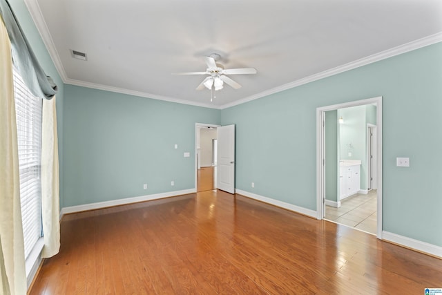 empty room with ornamental molding, ceiling fan, and light hardwood / wood-style floors