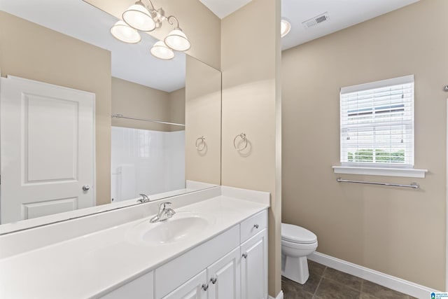 bathroom featuring vanity, tile patterned flooring, toilet, and walk in shower