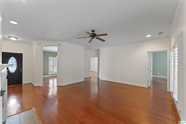 entrance foyer with wood-type flooring, ornamental molding, and ceiling fan