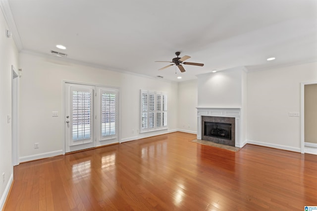 unfurnished living room with crown molding, ceiling fan, a fireplace, and light hardwood / wood-style flooring