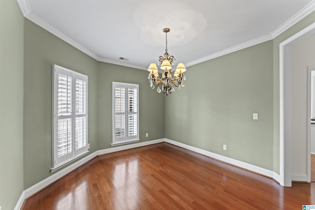 unfurnished room featuring hardwood / wood-style floors, crown molding, and a chandelier