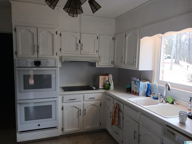 kitchen with black electric cooktop, white double oven, white cabinets, and dishwashing machine