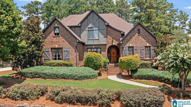 tudor-style house with a front lawn