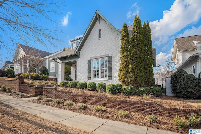 view of front of house with a gate and brick siding