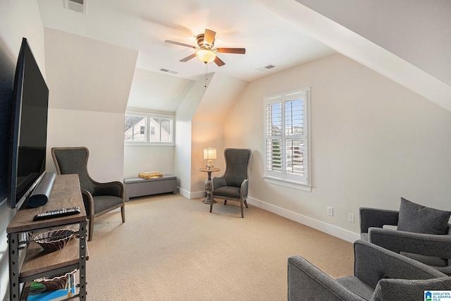 sitting room featuring vaulted ceiling, plenty of natural light, light colored carpet, and ceiling fan