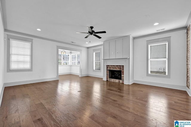 unfurnished living room with ceiling fan, crown molding, a fireplace, and wood-type flooring