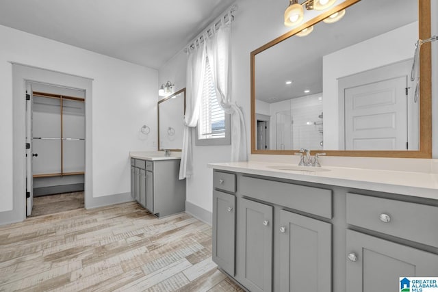 bathroom featuring walk in shower and vanity