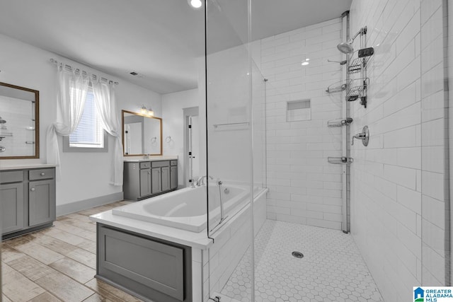 bathroom featuring vanity, separate shower and tub, and wood-type flooring