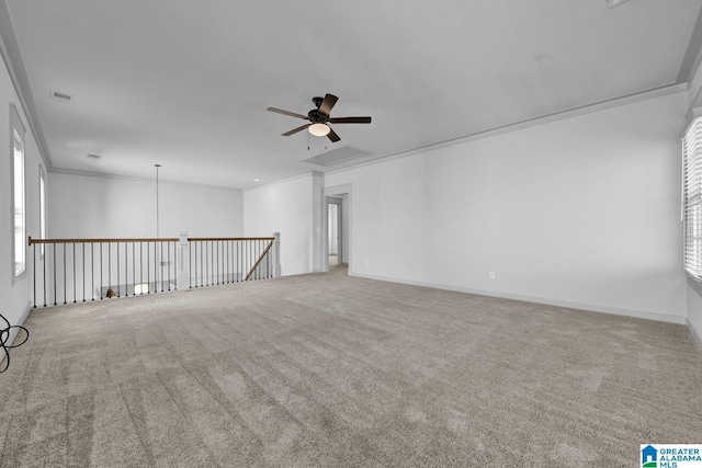 carpeted spare room with ceiling fan and ornamental molding