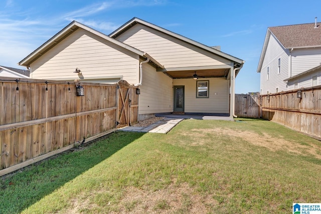 rear view of house with a yard, ceiling fan, and a patio area