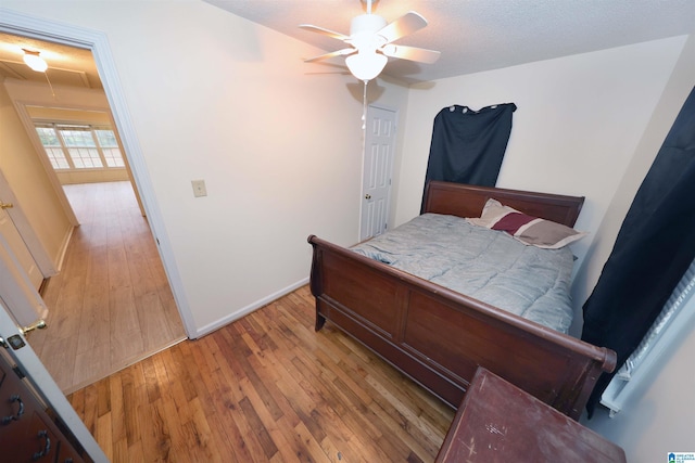 bedroom featuring ceiling fan, a textured ceiling, and light wood-type flooring